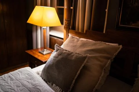 Lamp on a night table next to a bed Stock Photos