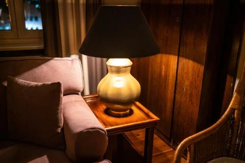 Lamp on a night table next to a bed Stock Photos
