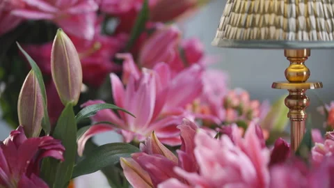 A lamp is placed in front of a bunch of pink flowers Stock Footage 297773694