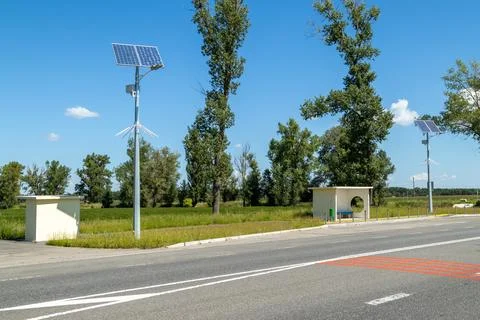 Lamp post with solar panel system on road with blue sky and trees. Autonomous Stock Photos