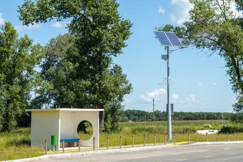 Lamp post with solar panel system on road with blue sky and trees. Autonomous Foto stock