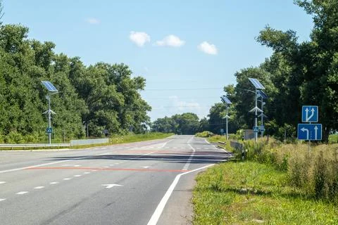 Lamp post with solar panel system on road with blue sky and trees. Autonomous 스톡 사진