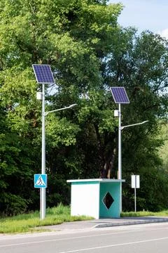 Lamp post with solar panel system on road with blue sky and trees. Autonomous 스톡 사진
