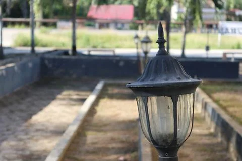 Lamp post stands sentinel in a tranquil park setting with natural light Stock Photos