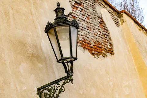A lamp post with a white light shining on a brick wall in Prague Czech Republ Stock Photos