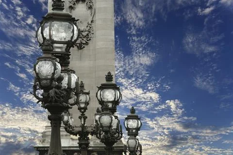Lamp posts on Alexander III Bridge against the sky with clouds. Paris, France Stock Photos