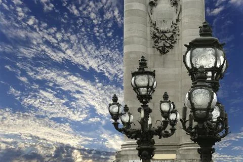 Lamp posts on Alexander III Bridge against the sky with clouds. Paris, France Stock Photos