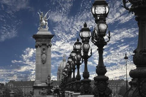 Lamp posts on Alexander III Bridge against the sky with clouds. Paris, France Stock Photos