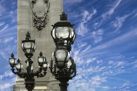 Lamp posts on Alexander III Bridge against the sky with clouds. Paris, France Stock Photos