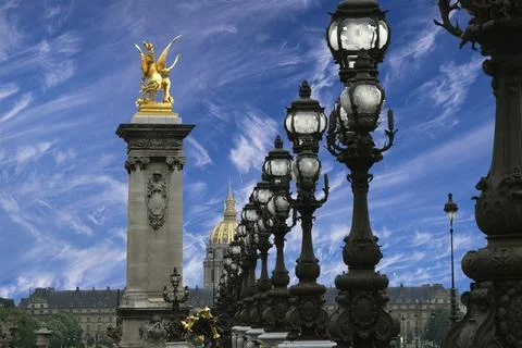 Lamp posts on Alexander III Bridge against the sky with clouds. Paris, France Stock Photos