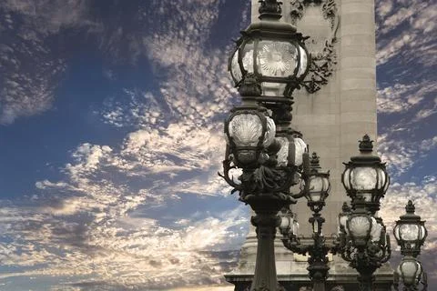Lamp posts on Alexander III Bridge against the sky with clouds. Paris, France Stock Photos