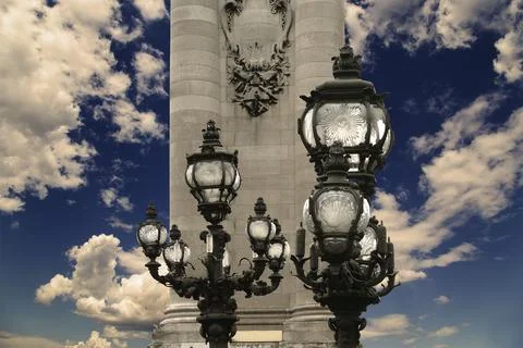 Lamp posts on Alexander III Bridge against the sky with clouds. Paris, France Stock Photos