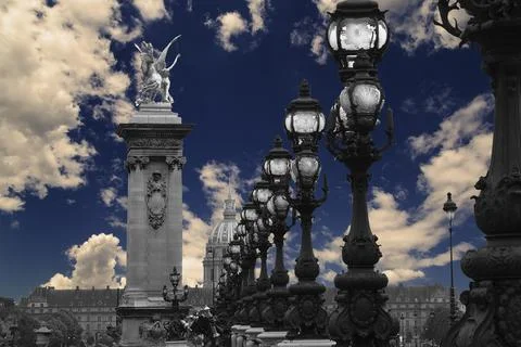 Lamp posts on Alexander III Bridge against the sky with clouds. Paris, France Stock Photos