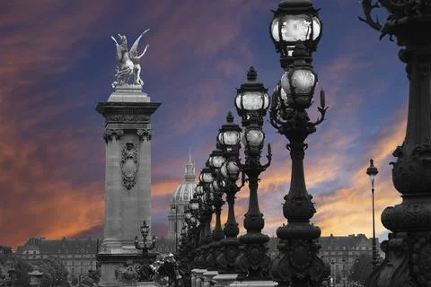 Lamp posts on Alexander III Bridge against the sky at sunset. Paris, France Stock Photos