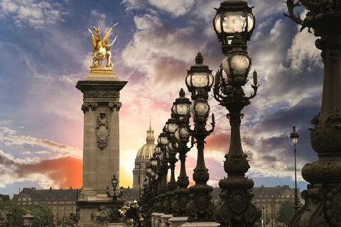 Lamp posts on Alexander III Bridge against the sky at sunset. Paris, France Stock Photos