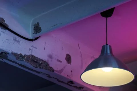 Lamp in shade on old ceiling. Lighting device on an old textural background Фото