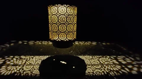 Lamp on the table at night. Yellow textures created by the shape of the lamp Stock Footage 223346006