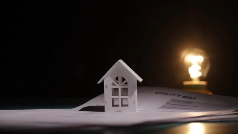 The lamp turns off against the backdrop of the utility bill and the house, .. Stock Footage 310373001