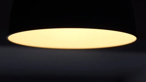 The lamp turns off. Bright warm light turns off in a dark room Stock Footage 111209897