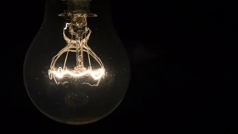 Lamp turns on in the dark, light bulb shines brighter and brighter. New idea Stock Footage 83231876