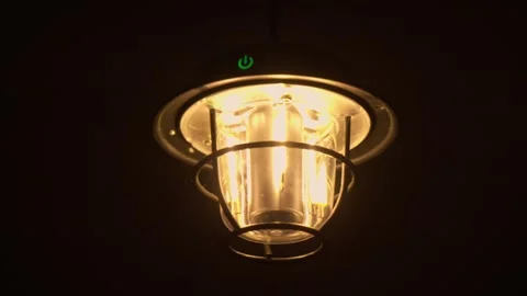 A lamp with warm light swinging in the wind in the dark. Stock Footage 300561194