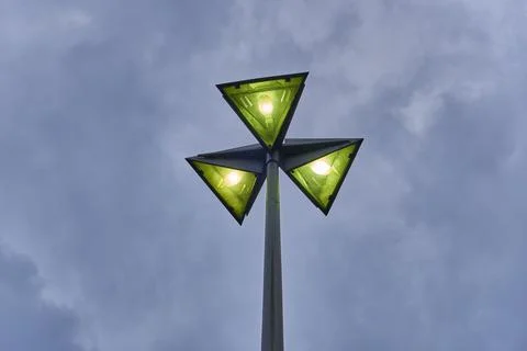 Lamppost with 3 triangular lights over sky with clouds 写真素材