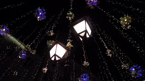 Lamppost around hanging luminous bulbs on the street at night 스톡 동영상 115364541
