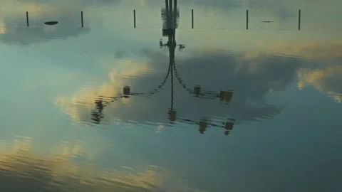 Lamppost on the Background of Cloudy Sky Reflected in the Water of the Street Stock Footage 158890406
