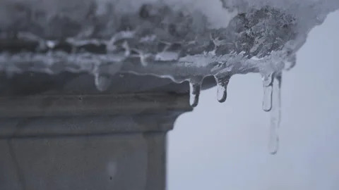 Lamppost foundation with snow falling and icicles thawing 스톡 동영상 295291904