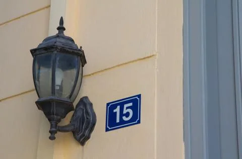 Lamppost on the wall of house number 15 Stock Photos