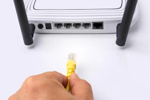 LAN network switch with ethernet cables plugging in on white Stock Photos