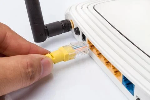 LAN network switch with ethernet cables plugging in on white Stock Photos