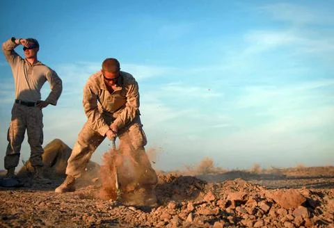 Lance Cpl. Kyle Harbour of Seattle digs a hole to sleep in for the night d... Stock Photos