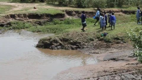 Land Cruiser Passes through Muddy Stream as Children Stand Aside  (HD) Stock Footage 7680775