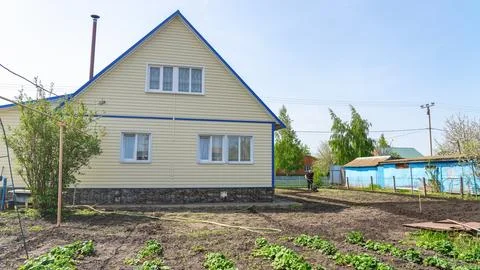 Land plot in front of cottage for gardening. Martyr in black clothes in summer Stock Photos