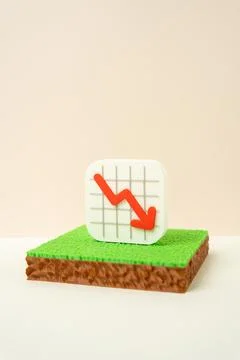 Land plots and declining chart, decreasing land value concept. Falling prop.. 写真素材