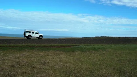 Land Rover Defender Driving Down The Road In Iceland - Panning Shot Stock Footage 83668891