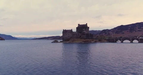 Land Rover Defender, at Eilean Donan Castle, seagull in shot drone aerial 4K Stock Footage 104584349