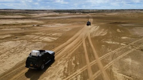 Land Rovers Driving Through Sandy Desert Landscape Vidéo 330738576