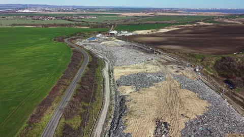 Landfill area in a rural setting with marked boundaries and nearby fields, Stock Footage 331071919