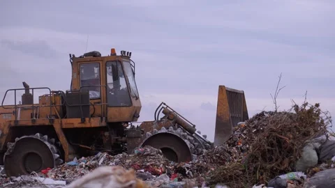 Landfill compactor moving and compacting municipal waste Stock Footage 326148157