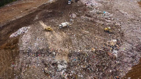 Landfill. A huge pile of garbage surrounded by forest. Garbage trucks carry Stock Footage 337444274