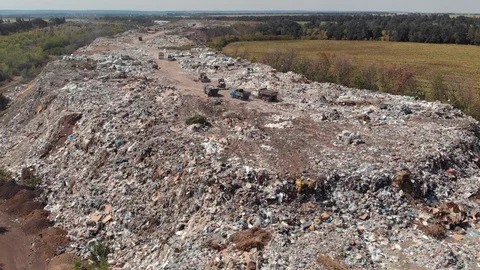 A landfill in the middle of the fields with garbage trucks and workers. Video stock 114489966