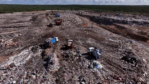 Landfill with solid household waste. Garbage truck unloads rubbish Stockbeeldmateriaal 212012452
