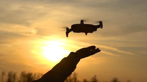 Landing a quadcopter in the hand. Person takes drone in his hand Stock Photos
