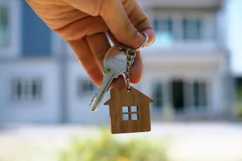 Landlord unlocks the house key for new home Stock Photos