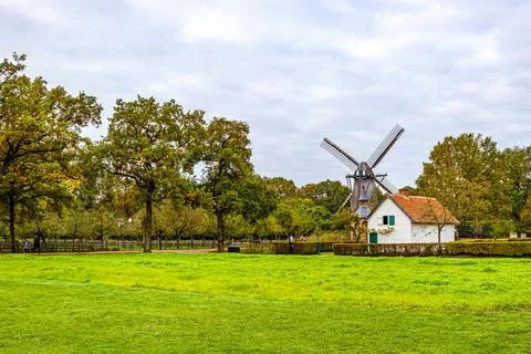 Landscape of agricultural plot with green grass, farmhouse and windmill 写真素材
