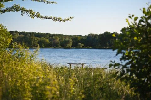 Landscape with a bench by the river Stock Photos