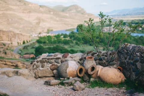 Landscape with ceramic amphora for wine on a background of mountains outdoors . Stock Photos