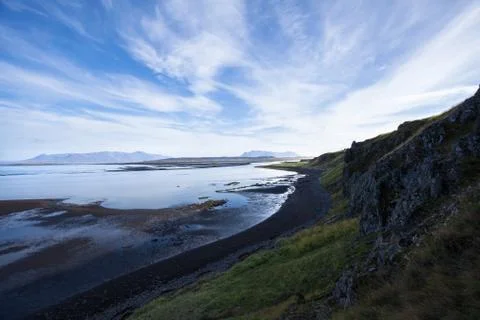 Landscape with cliff and mountain range at the ocean. Light reflections in .. Stock Photos